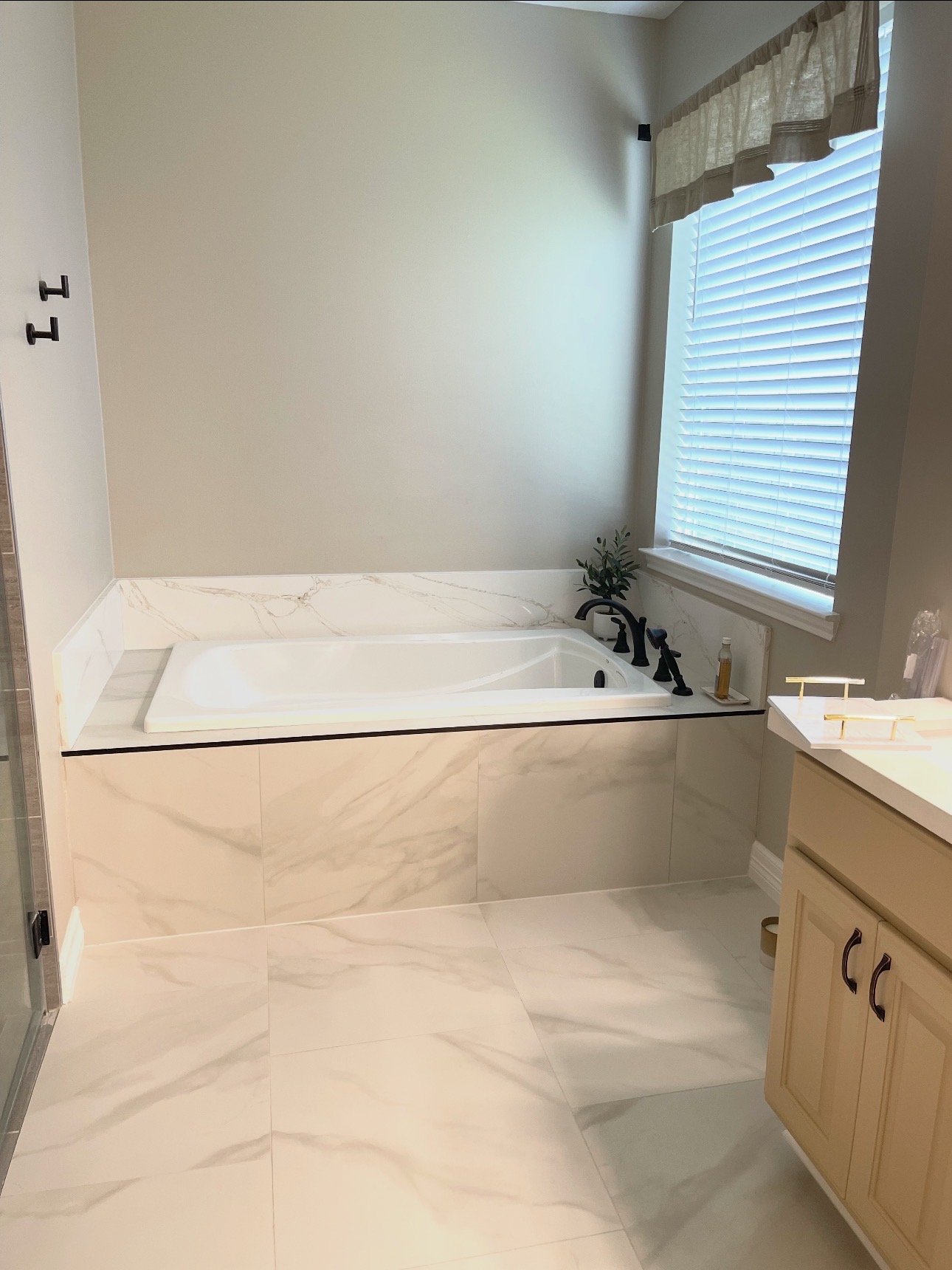 Marble-tile drop-in tub with black fixtures