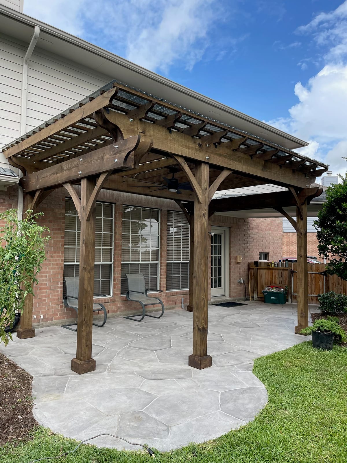 Cedar pergola over a stamped stone patio