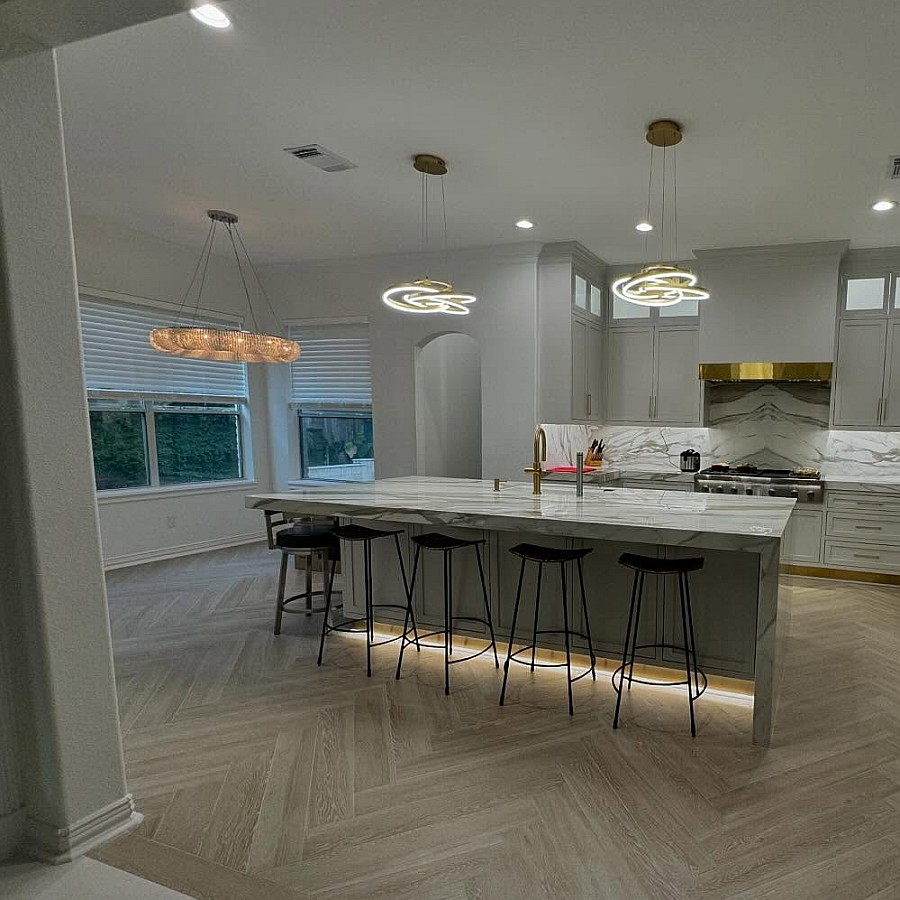 Kitchen remodel with herringbone wood floor and waterfall marble island by Art & Floors